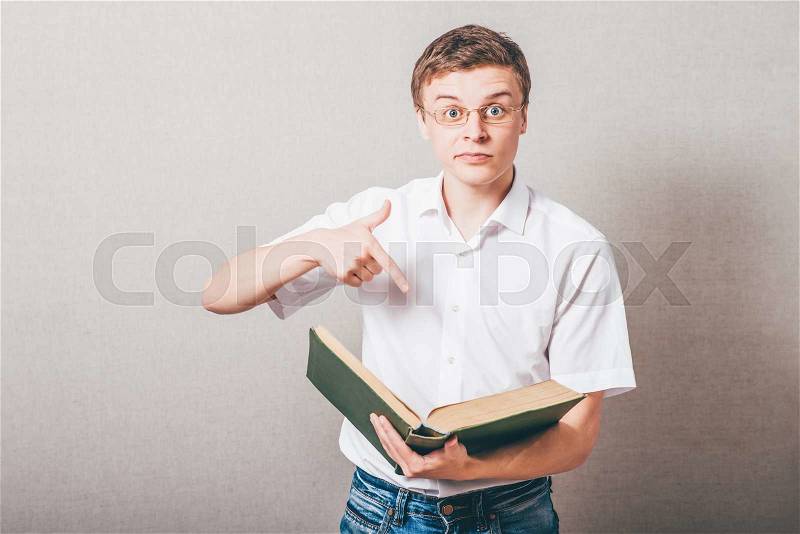 A man in glasses reading a book smart. On a gray background, stock photo