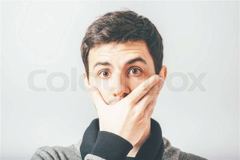Man closed his mouth with his hand, stock photo