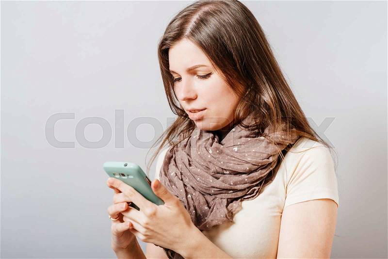 Image of young female reading sms on the phone , stock photo