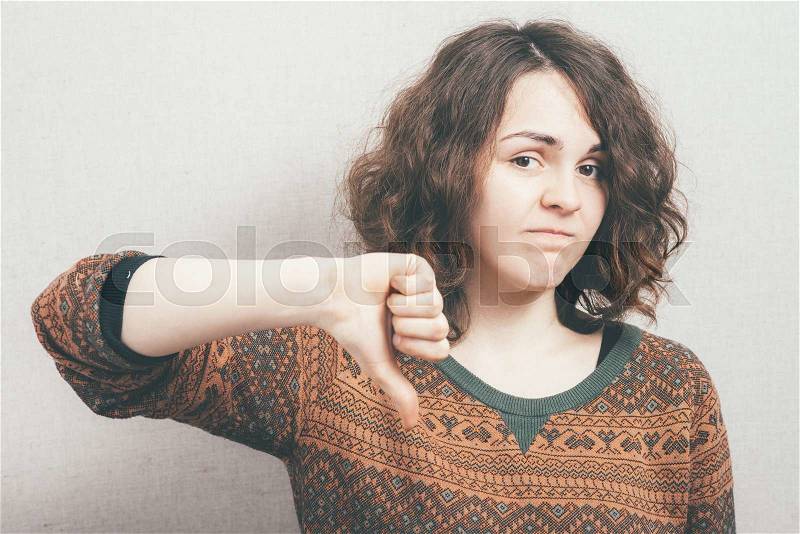 Woman showing thumbs down, stock photo