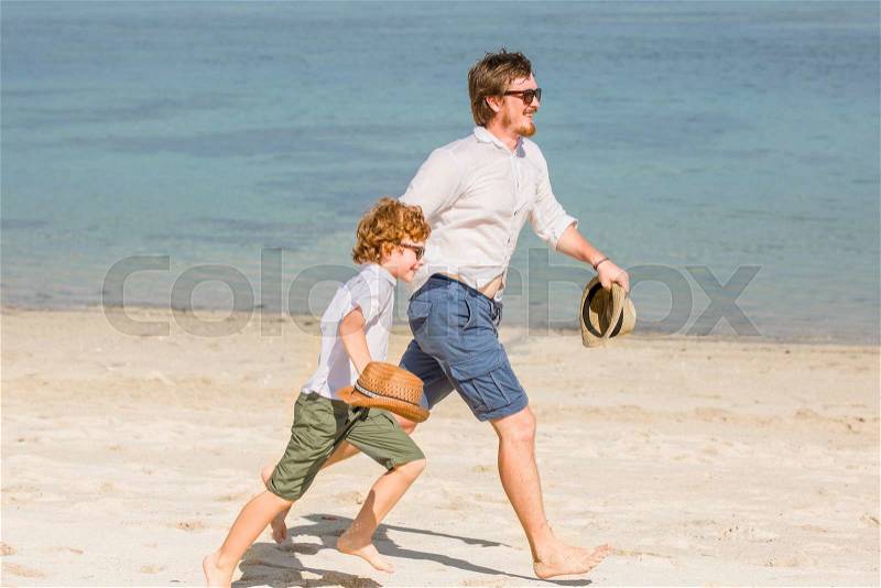 Hipster father with beard and red haired son having great happy time at a summer day. Vacation, happy and friendly family, holidays concept, stock photo