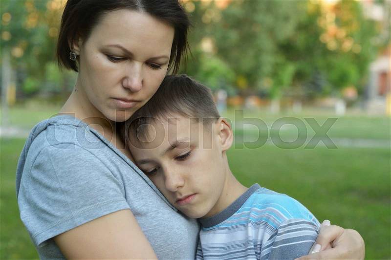 Sad mother with son on a walk in summer park, stock photo