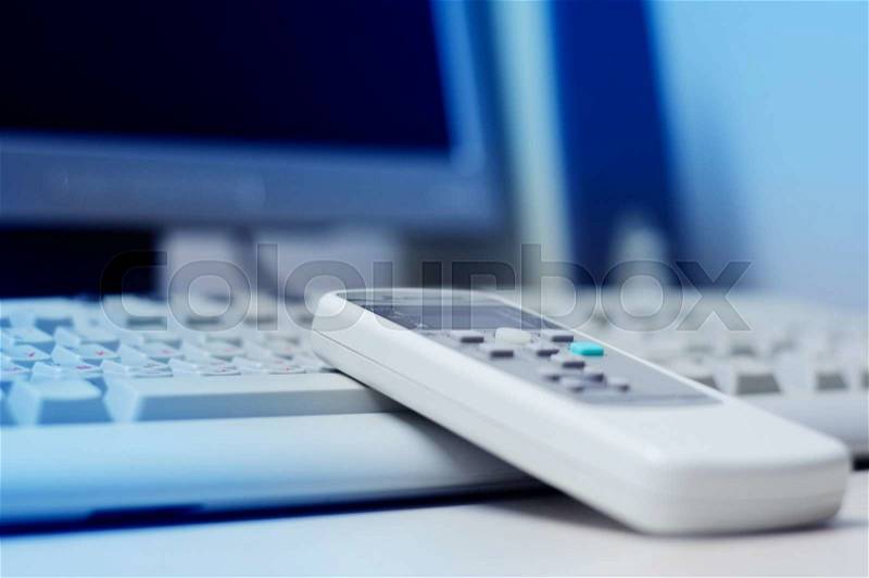 Remote control of air conditioning on computer keyboard in modern office, stock photo