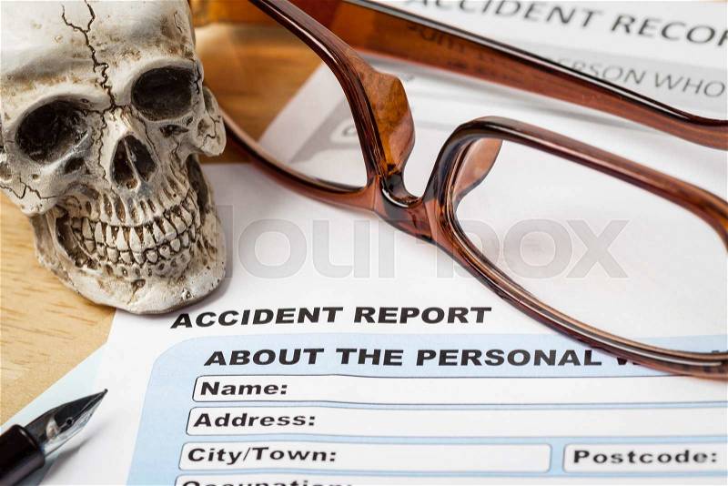 Accident report application form and human skull on brown envelope and eyeglass, business insurance and risk concept; document is mock-up, stock photo
