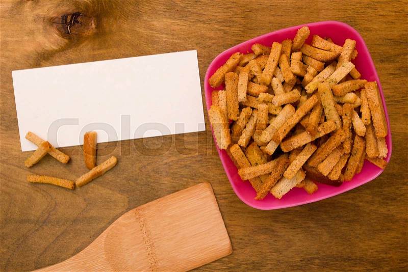 Grain crackers to add to soups. Plastic container with a wooden spoon, stock photo