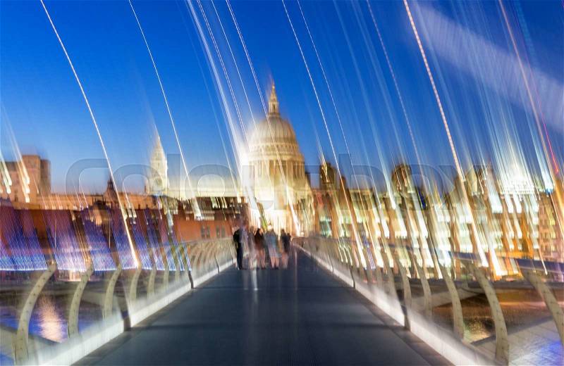 Blurred image of people moving along Millennium Bridge, London, stock photo
