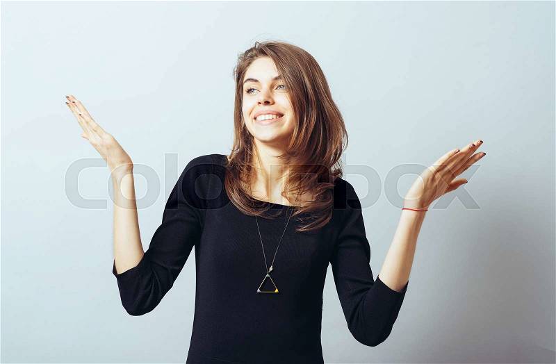 Young woman with arms out shrugs shoulders asking who cares so what I don\'t know, stock photo