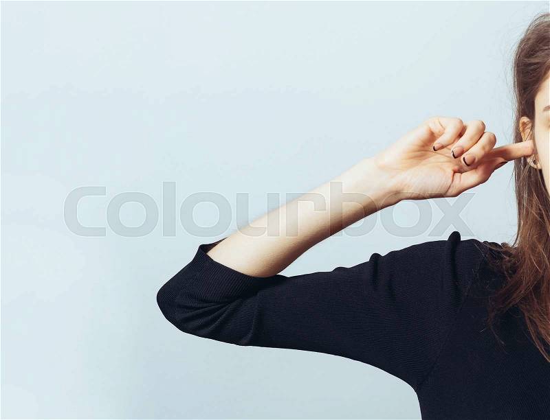 A frustrated pretty woman putting her finger in her ear, stock photo
