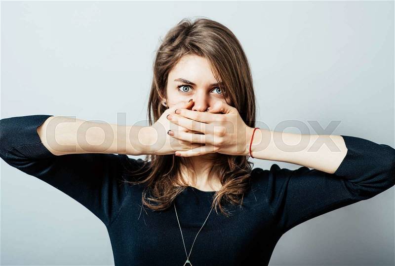 Woman with hand over her mouth, stock photo