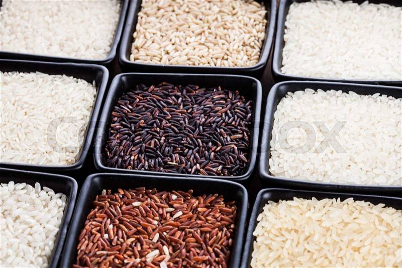 Various types of rice in black bowls close up, stock photo