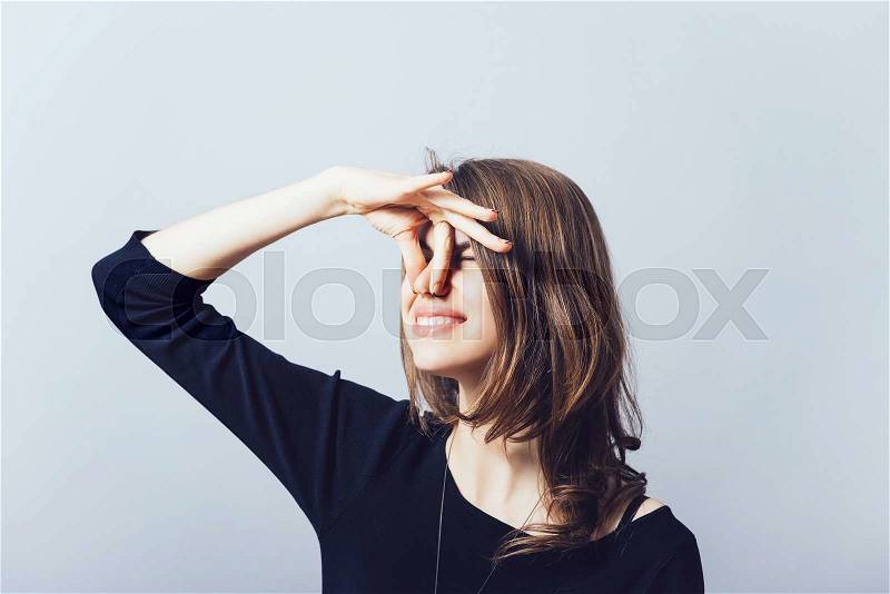 Closeup side view profile portrait young woman, disgust on face, pinches nose, something stinks, very bad smell, situation, isolated gray background. Negative human emotion facial expression feeling, stock photo