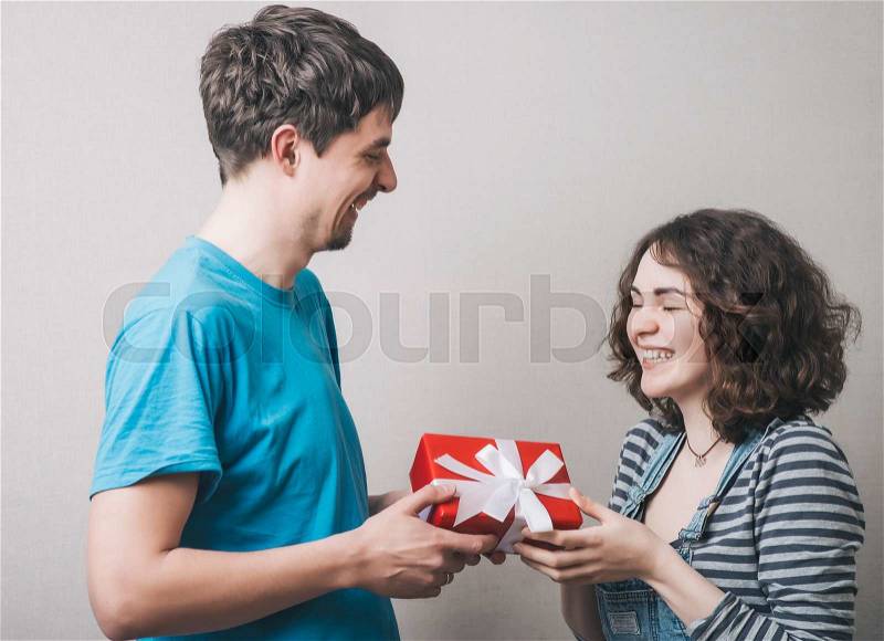 Valentine Gift. Happy Young Couple with Valentine\'s Day Present. Happy Man giving a gift to his Girlfriend. Holiday, stock photo