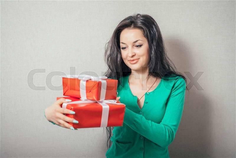 Portrait of casual young happy smiling woman hold red gift box. Isolated studio background female model, stock photo