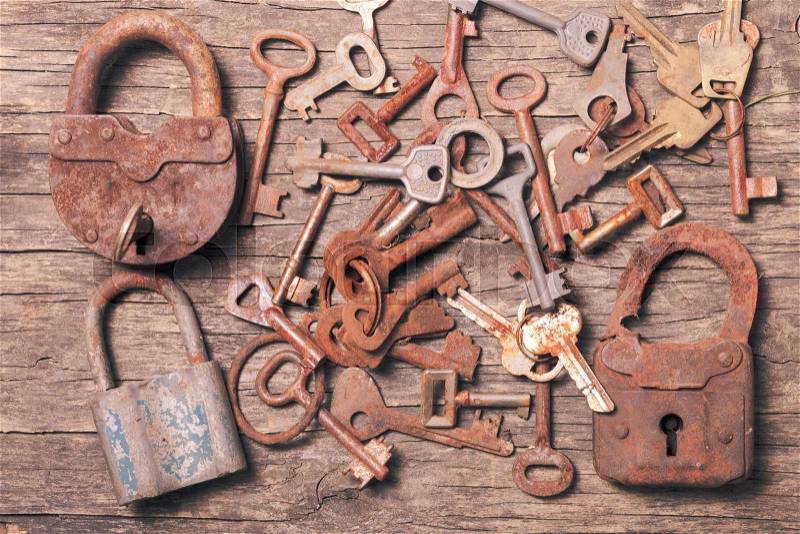Old keys locks over vintage wooden table, stock photo