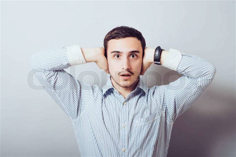 Man covers his ears from the noise, stock photo