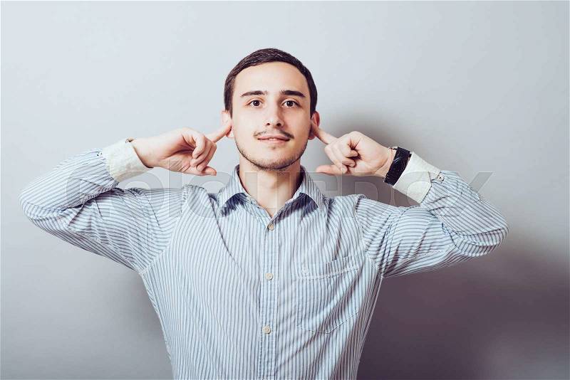 Man covers his ears from the noise, stock photo