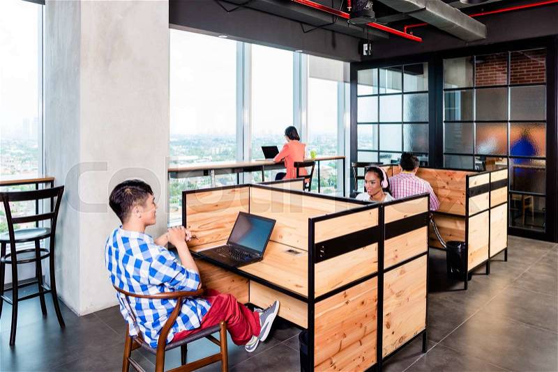 Start-up business people in coworking office working in cubicles, stock photo