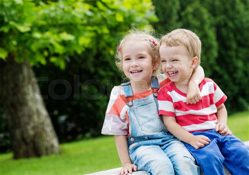 Happy Toddler brother and sister hugging in summer, stock photo