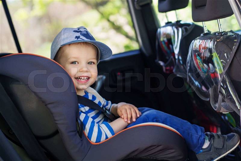 Portrait happy toddler boy sitting in the car seat, stock photo