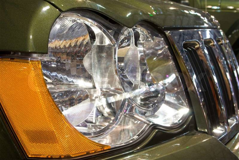 Close-up of a new modern car: head lamp and radiator, stock photo