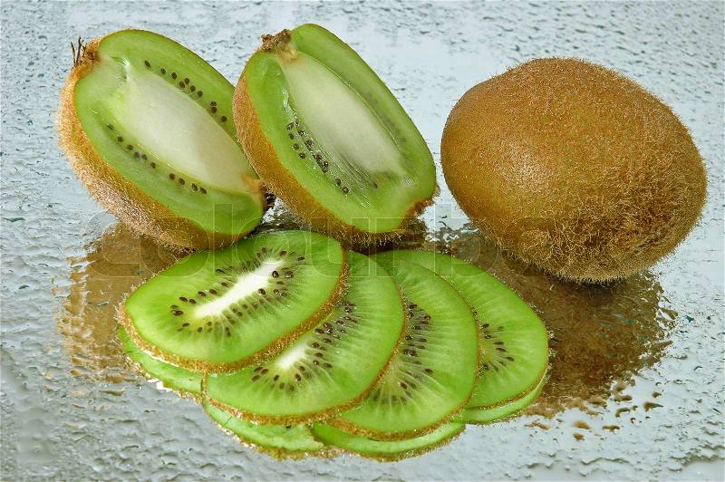 Cut kiwifruit on wet mirror, stock photo