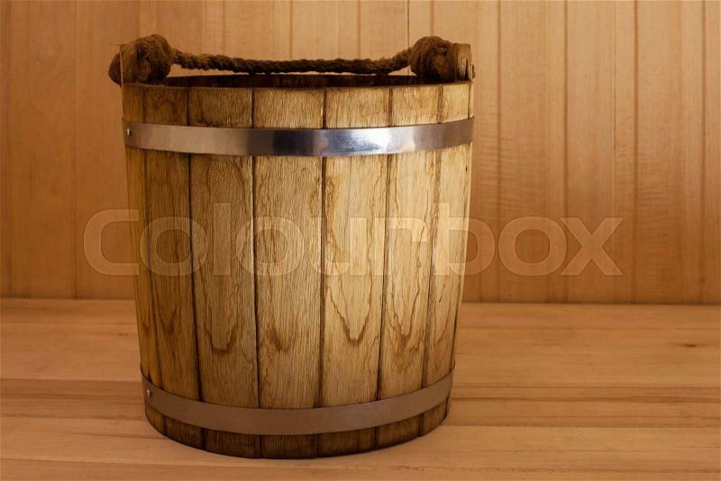 Old wooden bucket on wooden background in sauna, stock photo
