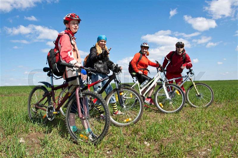 A group of four adults on bicycles in the countryside. Everyone can ride a bike. Everyone who rides a bike is my friend, stock photo
