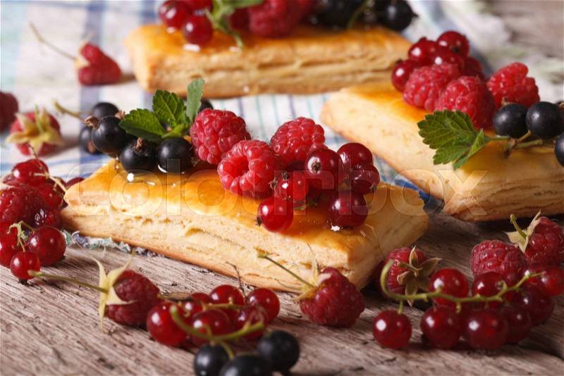 Homemade cakes with raspberries, currants, honey and mint on a table close-up. , stock photo
