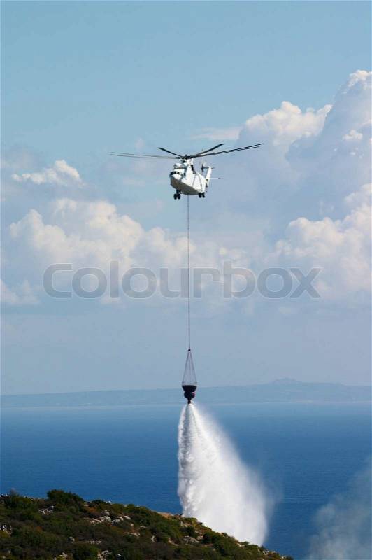 Fire fighting helicopter put out forest fire, stock photo
