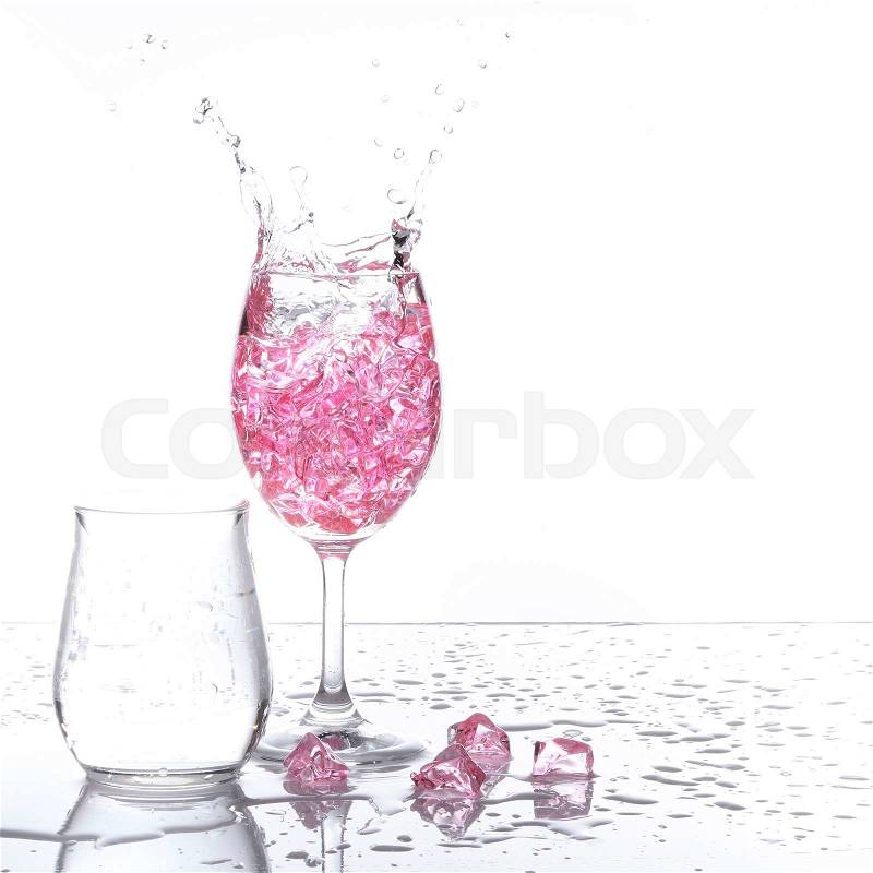 Stemmed champagne glass with liquor splashing out, isolated on white background, stock photo