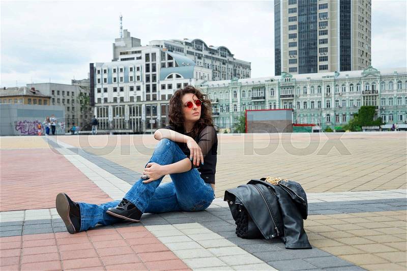 Glamorous young brunette woman in round red sunglasses having fun in the city, stock photo