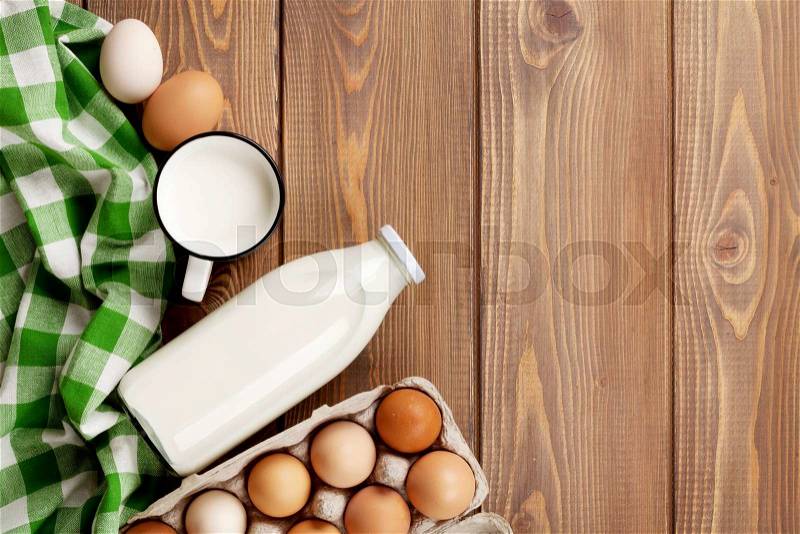 Dairy products on wooden table. Milk and eggs. Top view with copy space, stock photo
