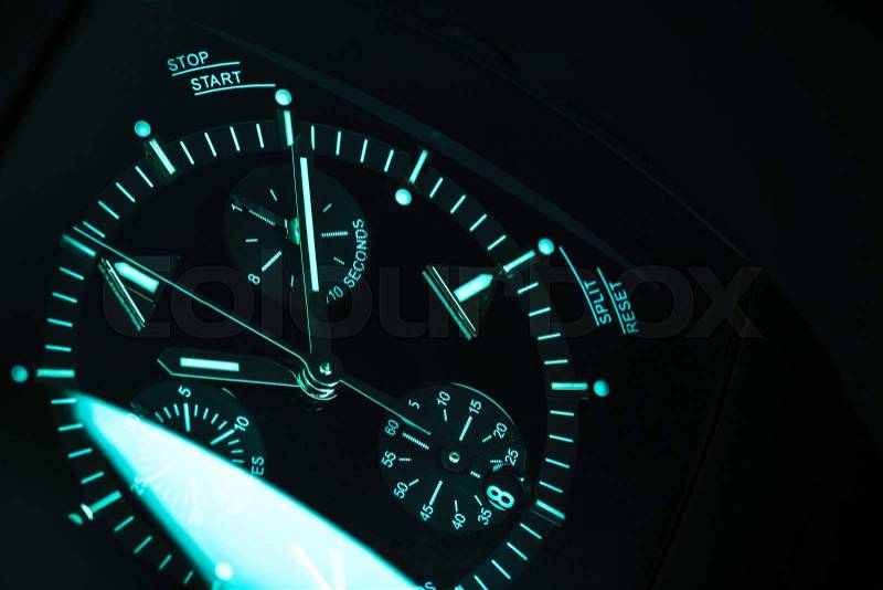 Luxury mens Chronograph Watch, clock deal with blue green illumination. Close-up blue toned studio photo with selective focus, stock photo