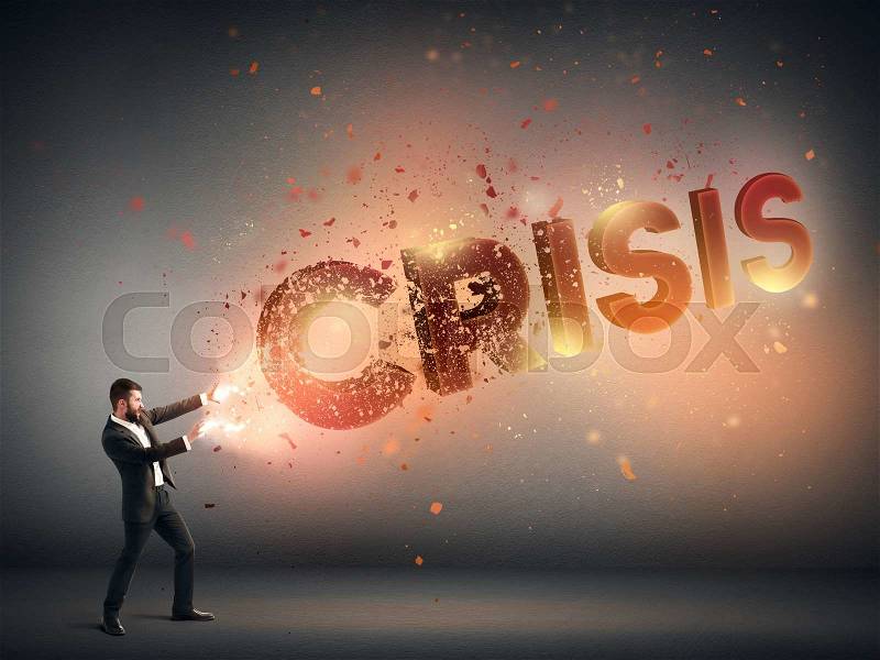 Strong businessman destroying word crisis with magic from his hands in dark room, stock photo