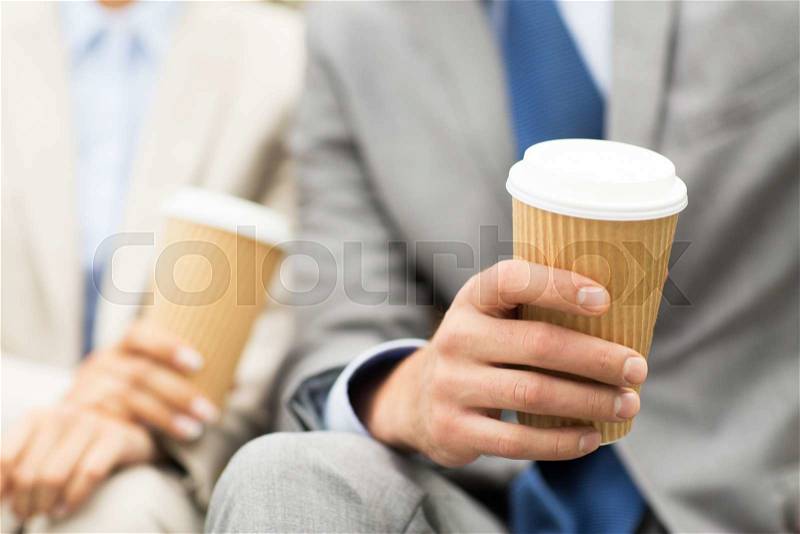 Business, hot drinks and people concept - close up of business people hands with coffee cups, stock photo