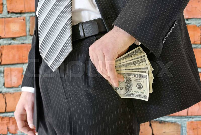 Man in a business suit put money in your pocket, stock photo