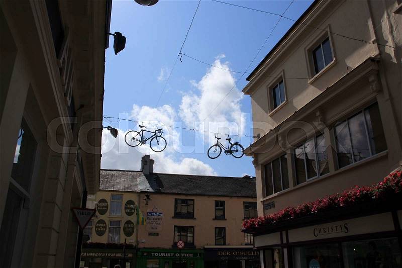 Attraction, two bikes hang on the cable for the show in the shopping centre of Killarney in Ireland in the summer, stock photo