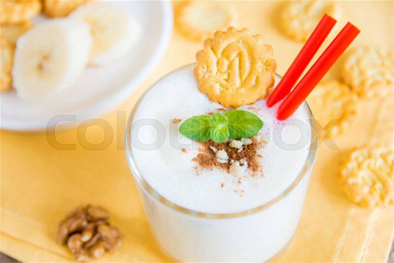Milkshake (banana smothie) in glass with mint, nuts and homemade cookies, breakfast horizontal close up, stock photo