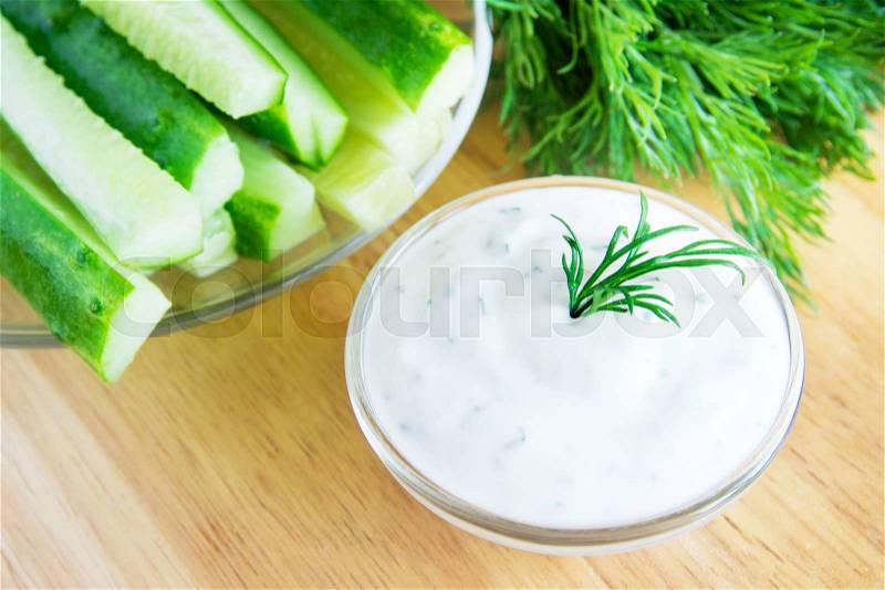Greek Tzatziki yogurt dip (sauce) and ingredients on wooden table, stock photo