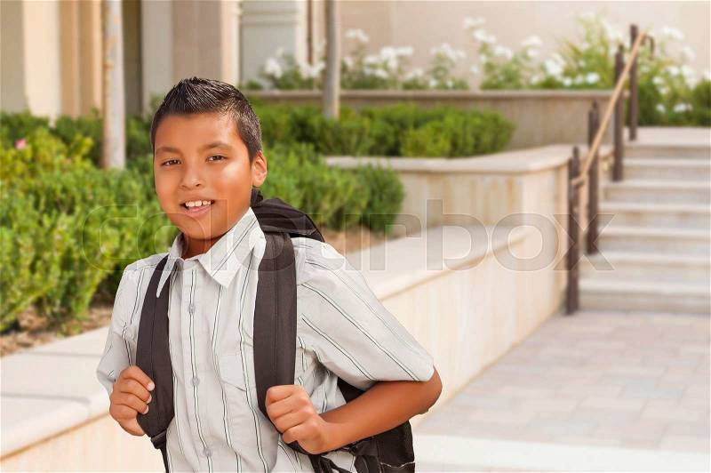 Happy Hispanic Boy with Backpack Walking on School Campus, stock photo