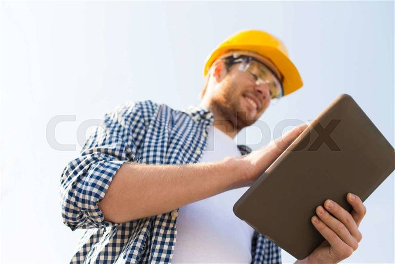 Business, building, industry, technology and people concept - close up of smiling builder in hardhat with tablet pc computer outdoors, stock photo