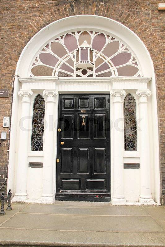 A striking black front door in one of the famous streets in the city Dublin in Ireland in the summer, stock photo