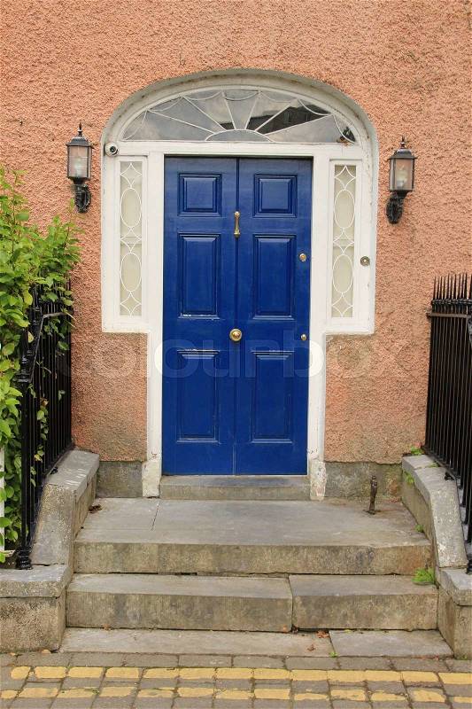 Terraced house and a striking blue front door in the residential area in the town Cahir in Ireland in the summer, stock photo