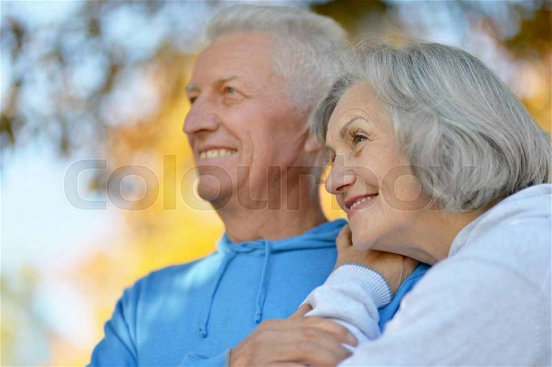 Happy senior couple relax in autumn park,back view, stock photo