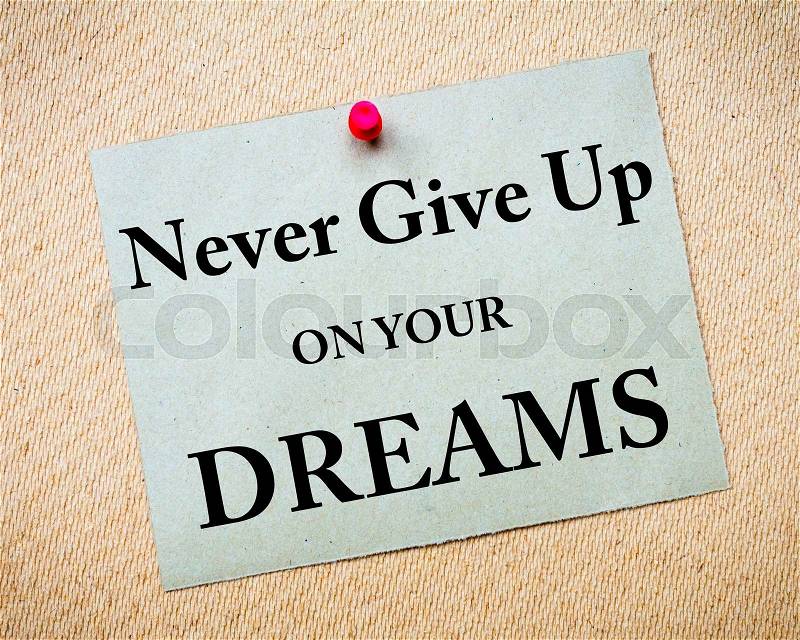 Never Give Up On Your Dreams Message written on recycled paper note pinned on cork board. Motivational concept Image, stock photo