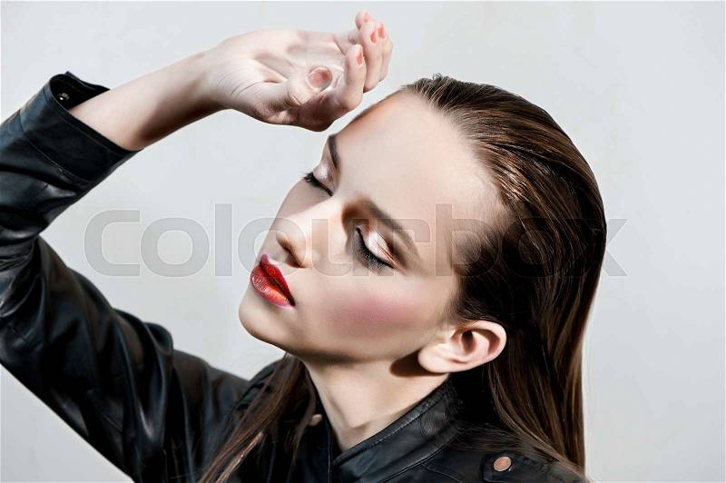Fashion girl with pink lips posing in black leather jacket, stock photo