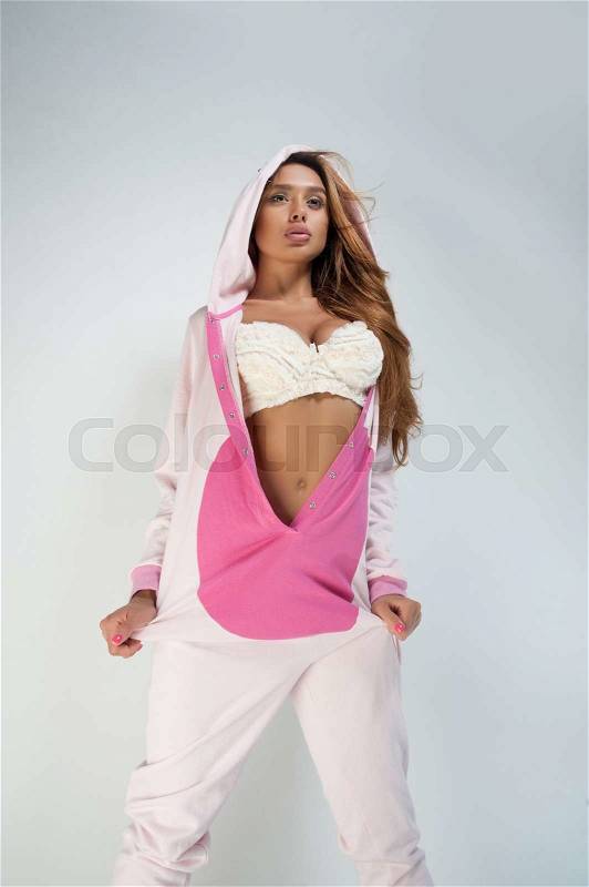 Hot girl with long hair poses in pig suit, stock photo