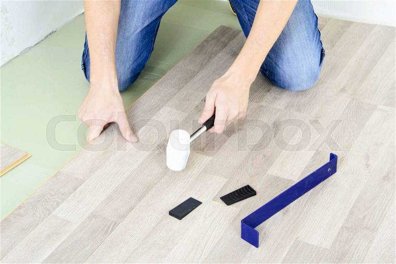 Man with Tools to Laying Laminate. Working time, stock photo