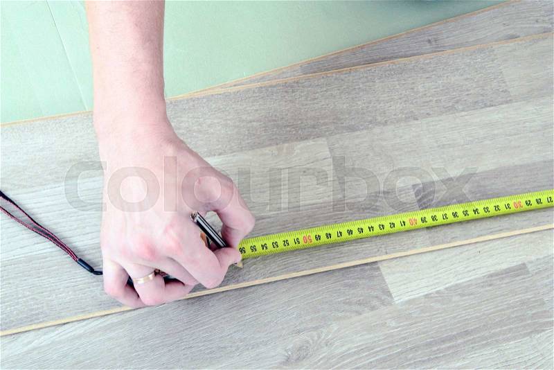Man with Tools to Laying Laminate. Working time, stock photo
