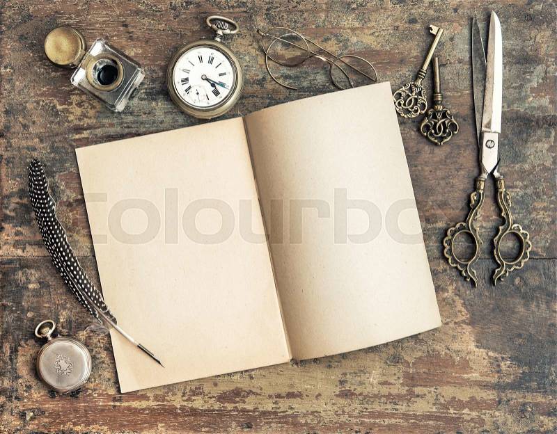 Still life with open book and antique writing tools on wooden background. Retro style toned picture, stock photo